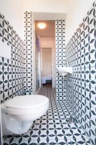 a bathroom with a toilet and a black and white tile floor at Ellena Sunshine in Opatija