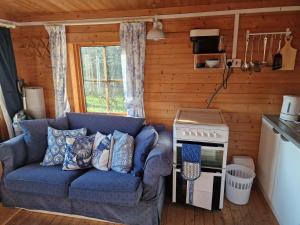 a living room with a blue couch and a stove at Cherry Orchard Retreat in Chideock