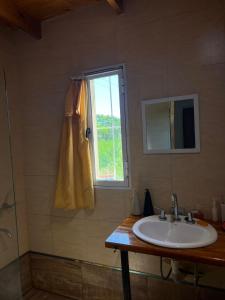 a bathroom with a sink and a window at Casa en Andino con pileta in Andino