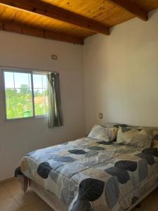 a bedroom with a bed in a room with a window at Casa en Andino con pileta in Andino