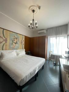 Un dormitorio con una cama grande y una lámpara de araña. en Hotel La Bussola, en Cittiglio