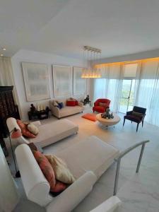 una gran sala de estar con muebles y ventanas blancos. en Dondi's Way - a private vacation home in the heart of Tagaytay City, en Tagaytay