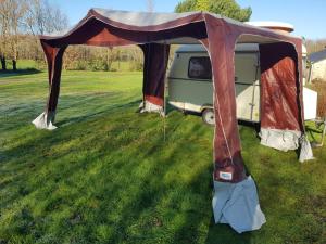 a tent sitting in the grass next to a van at La Eriba Puck in Nort-sur-Erdre