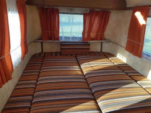 a large bed in a small room with windows at La Eriba Puck in Nort-sur-Erdre