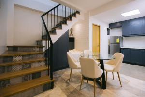 a dining room with a table and chairs and a staircase at 10 Oxford Residences in Quezon City