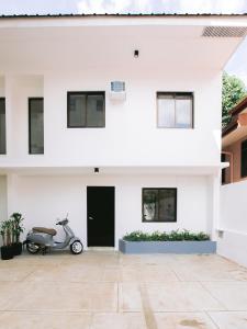 a scooter parked in front of a white house at 10 Oxford Residences in Quezon City