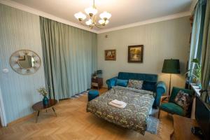 ein Wohnzimmer mit einem blauen Sofa und einem Bett in der Unterkunft Vintage boutique Old Town Warsaw in Warschau