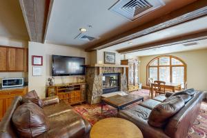 a living room with a leather couch and a fireplace at Red Hawk Lodge 2200 in Dillon