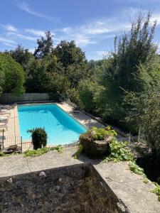 a swimming pool in a yard with trees at Le Manoir De St Marcel in Saint-Marcel-du-Périgord