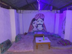 a room with a painting of a man and a woman at Hotel Old Moon Cafe in Pushkar