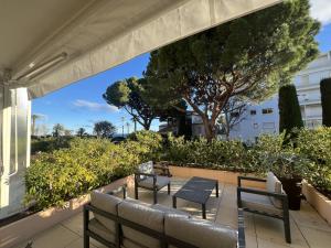 a patio with two benches and a tree at Rosalia Luxury 3 bedrooms near beaches by Welcome to Cannes in Cannes