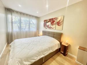 een slaapkamer met een groot bed en een raam bij Rosalia Luxury 3 bedrooms near beaches by Welcome to Cannes in Cannes