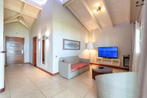 a living room with a couch and a flat screen tv at Palm Beach Resort & Spa in Ambondrona