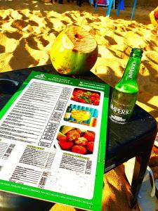 a newspaper and a bottle of beer on a table at Pousada e Restaurante J L . in Mangaratiba