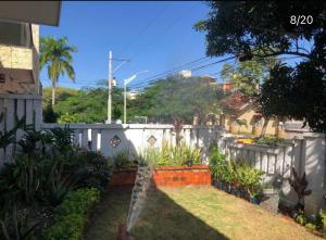 a backyard with a white fence and some plants at House prado in Barranquilla