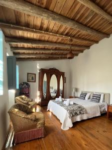a large bedroom with two beds and a chair at Vale de Camelos Country House, Alentejo, Portugal. in Alcaria Ruiva