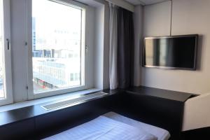 ein Hotelzimmer mit einem TV und einem Fenster in der Unterkunft Comfort Hotel Xpress Stockholm Central in Stockholm