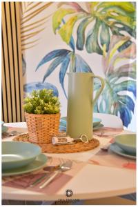 una mesa con una jarra verde y una planta en ella en DEA DREAMS Amendola Fiera Apartment Free Wi-Fi en Milán