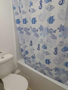 y baño con aseo y cortina de ducha. en Departamento Marina Sol, Coquimbo, en Coquimbo