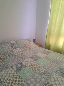 Una cama con un edredón encima. en Departamento Marina Sol, Coquimbo, en Coquimbo