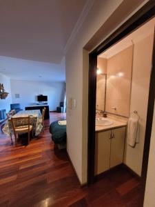 Habitación con baño con lavabo y dormitorio. en Complejo Abaurrea en Mendoza