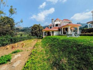 una casa seduta in cima a una collina erbosa di 3 Bedroom Private Villa-The Earthside by Futurve a Kodaikānāl