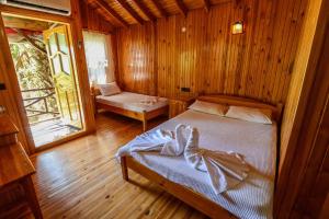 una camera da letto con un letto in una stanza di legno di YAVUZ MOTEL ADRASAN a Kumluca