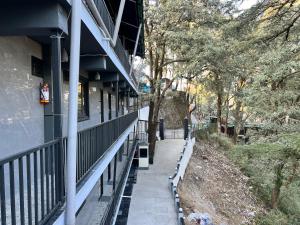 a sidewalk next to a building with a fence at Wabi Sabi Stays - Pride Inn in Mussoorie