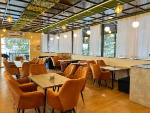a dining room with tables and chairs and windows at Wabi Sabi Stays - Pride Inn in Mussoorie