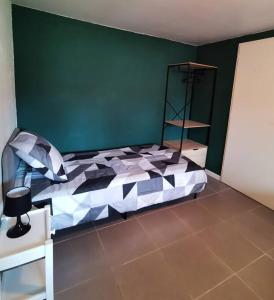 1 dormitorio con cama y pared verde en Entre pins et océan, en Onesse-et-Laharie