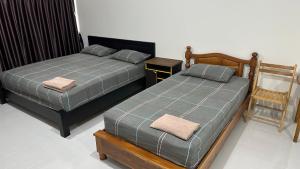 two beds sitting next to each other in a bedroom at Muangthongthani Rental/Khun Dan in Nonthaburi