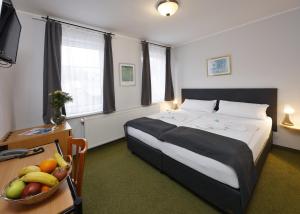 - une chambre avec un lit et une corbeille de fruits sur une table dans l'établissement Hotel Boston, à Karlovy Vary