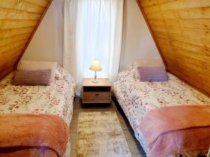 two twin beds in a room with a window at Chalé Zimbro, Serra da Estrela, Penhas da Saúde in Penhas da Saúde