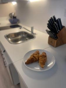 a plate with two croissants on a kitchen counter at Chamber St Apartments in London