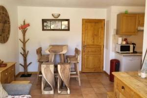 a kitchen with a table and chairs in a room at Joue du Loup, appartement F3, pied des pistes in Le Dévoluy