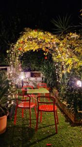 uma mesa e cadeiras num jardim à noite em La stanza degli abeti blu em Roma
