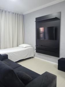 a living room with a tv and a couch at Via Venetto Flat Temporada in Fortaleza