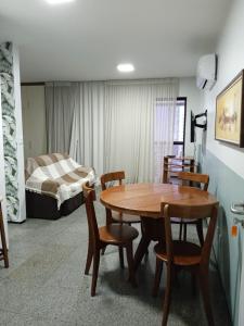 a room with a table and chairs and a bed at Via Venetto Flat Temporada in Fortaleza