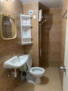 a bathroom with a toilet and a sink and a mirror at Muangthongthani Rental/Khun Dan in Nonthaburi