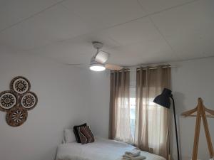 1 dormitorio con 1 cama y ventilador de techo en Feel Welcome Barcelona en Cornellà de Llobregat