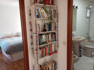 a book shelf filled with books next to a bedroom at Luxury renovated apartment with terrace in Madrid in Madrid
