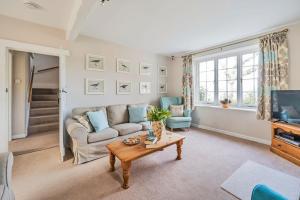 ein Wohnzimmer mit Sofa und Tisch in der Unterkunft East Cottage in Weymouth