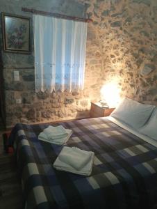 1 dormitorio con 1 cama con toallas en Ο ΘΟΛΟΣ en Stemnitsa