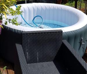 a bathtub with a hose in it with a bench at L'Ancre du Bessin - Proximité Bayeux et plages du débarquement - D-DAY - Spa en option - Accessible PMR in Saint-Vigor-le-Grand