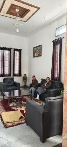 two men sitting on couches in a living room at MD Grand Hotel and resort in Agra