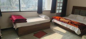 sypialnia z 2 łóżkami i oknem w obiekcie MD Grand Hotel and resort w mieście Agra