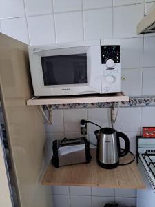 a microwave oven sitting on a shelf in a kitchen at Centro Rio Gallegos in Río Gallegos