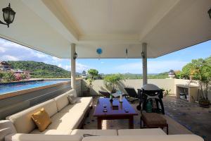 patio con divano, tavolo e piscina di Sea Ridge Penthouse by baansiesom a Khao Tao