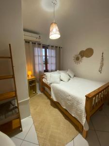 Quintal da Casa في غاروبابا: غرفة نوم بسرير كبير ومصباح