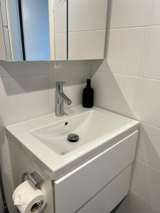 a white sink in a bathroom with a mirror at Simple studio for two in Turku Center in Turku